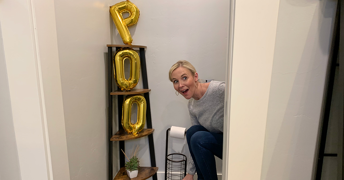 collin on toilet with gold balloons spelling out poo