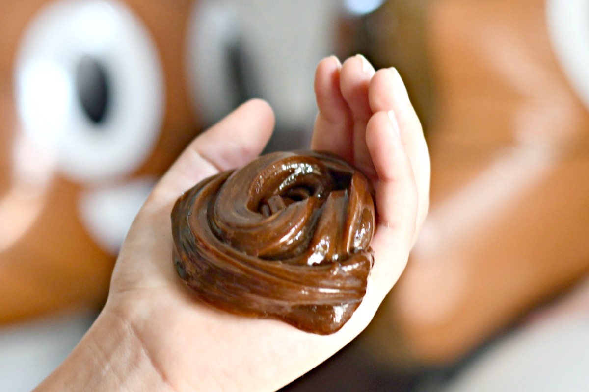 holding chocolate poop party slime in a swirly 